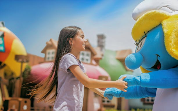 Girl interacting with a Smurf character at MOTIONGATE™ Dubai.