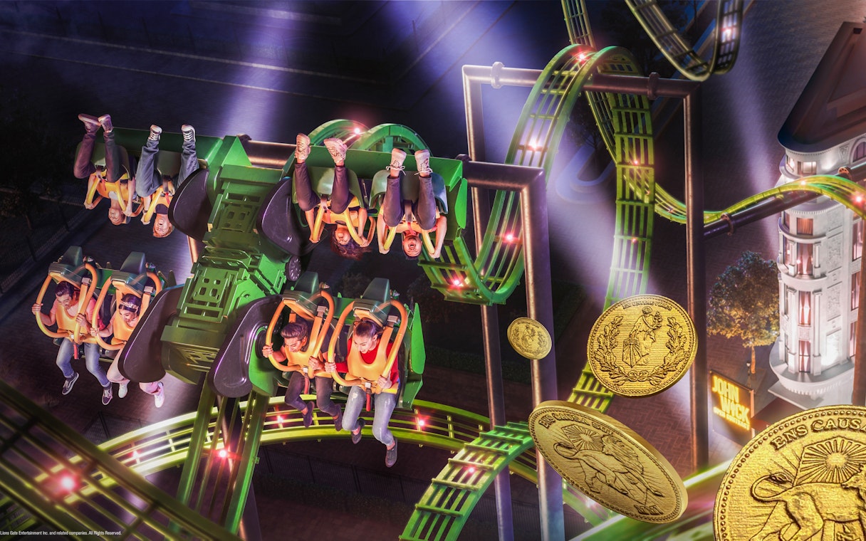 Roller coaster ride at MOTIONGATE™ Dubai with riders upside down, featuring illuminated tracks.