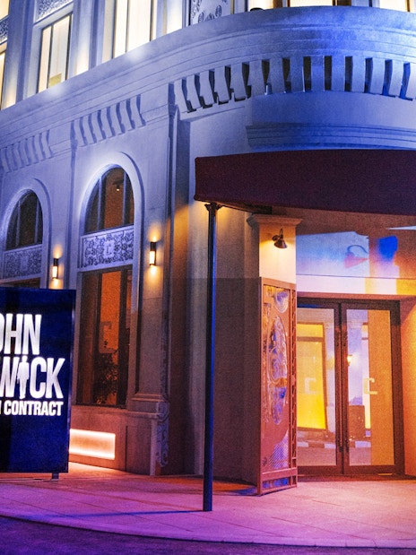 Entrance to John Wick attraction at MOTIONGATE™ Dubai, featuring illuminated sign.