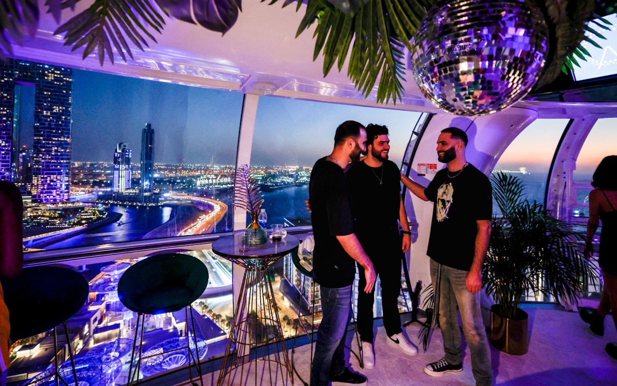 Group enjoying night view from Ain Dubai observation cabin.