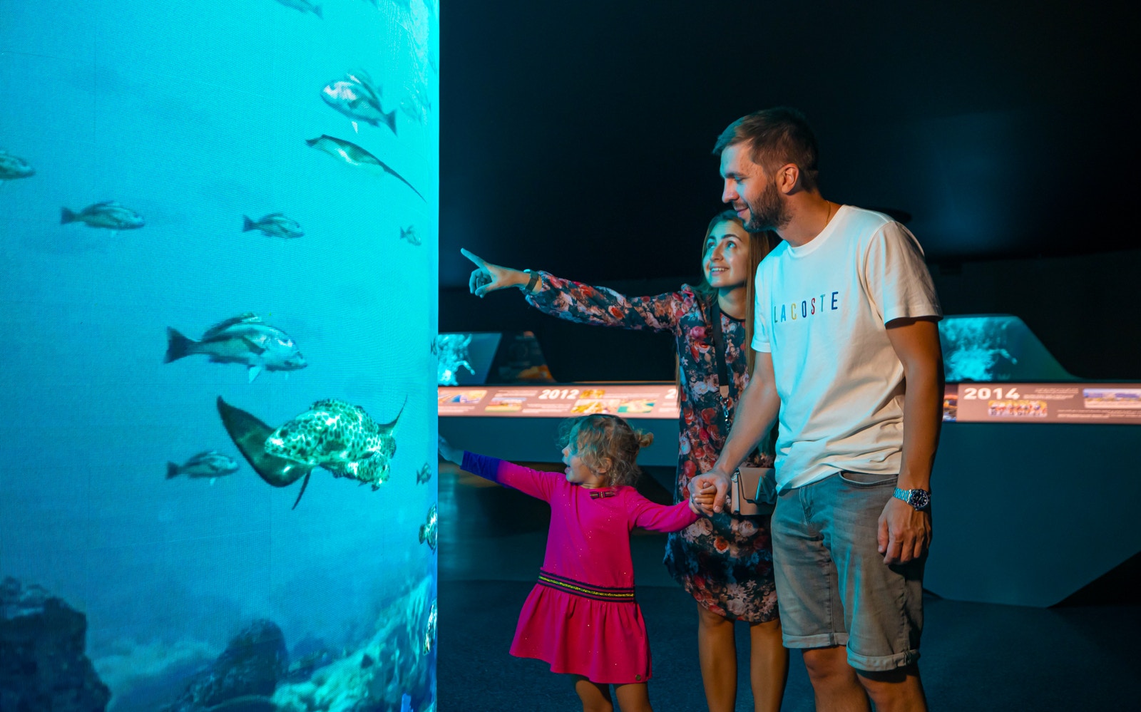 Family exploring an aquarium exhibit at The View at the Palm.
