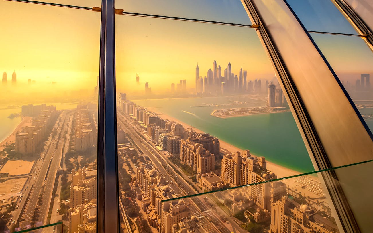 Sunrise view of Dubai skyline from The View at the Palm, overlooking the city and coastline.