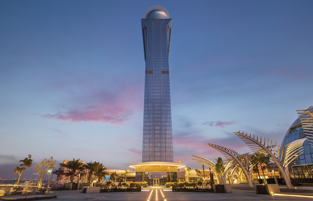 The View at the Palm tower at sunset, Dubai skyline in the background.