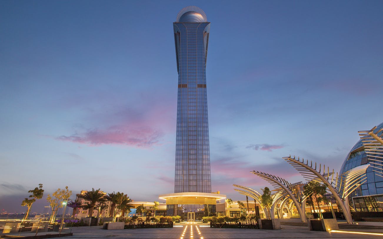 The View at the Palm tower at sunset, Dubai skyline in the background.