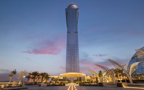 The View at the Palm tower at sunset, Dubai skyline in the background.