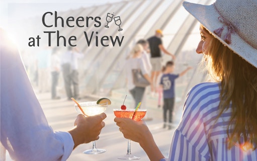 Couple toasting with cocktails at The View, Palm Jumeirah observation deck.