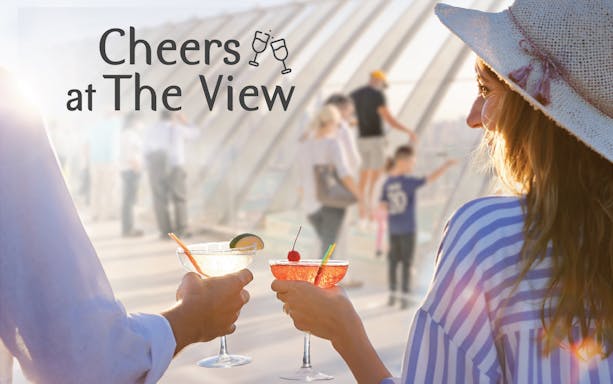 Couple toasting with cocktails at The View, Palm Jumeirah observation deck.