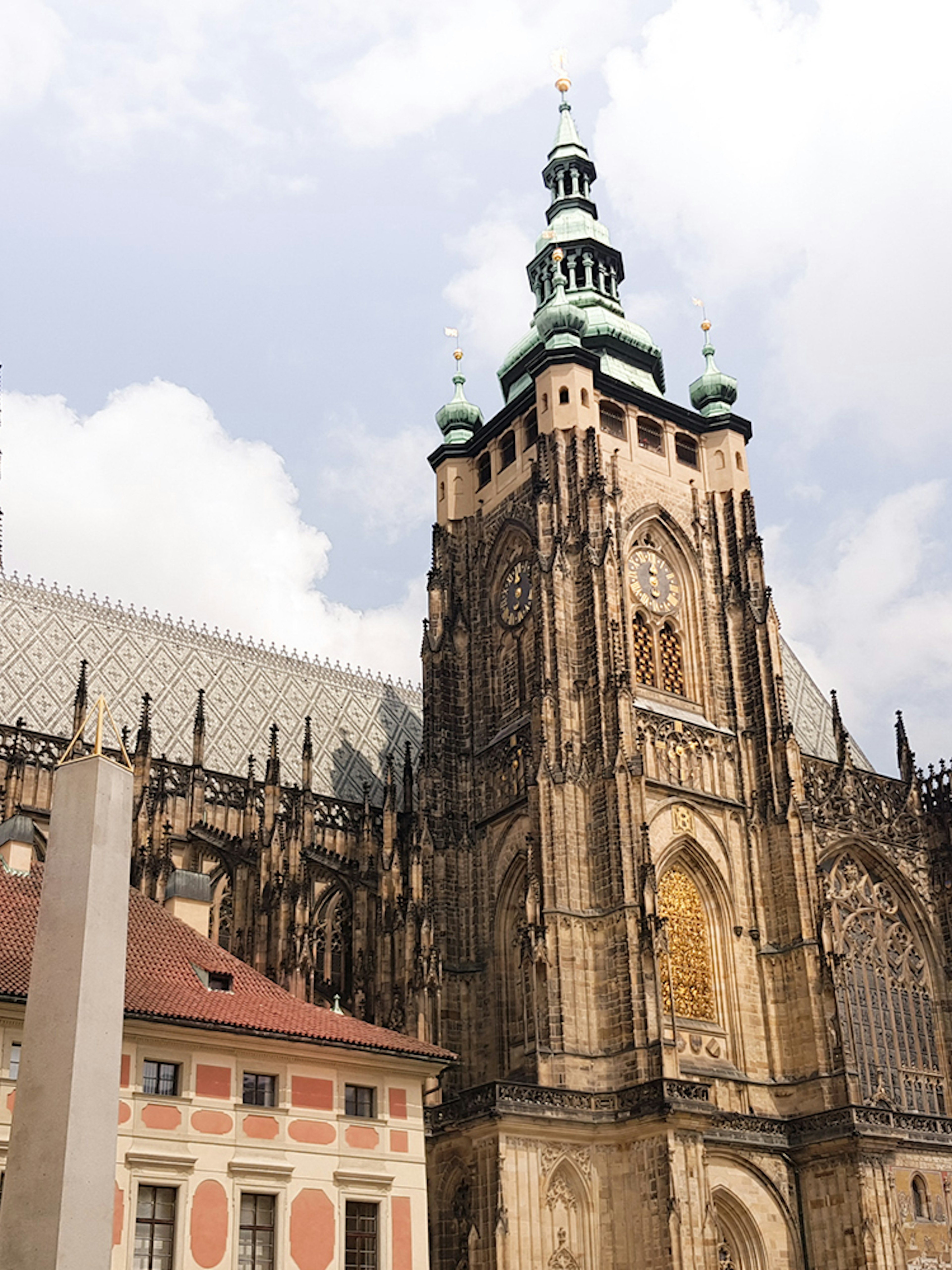 Prague Castle exterior with gothic architecture under a cloudy sky.