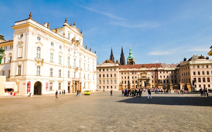 Prague Castle courtyard with tourists exploring historic architecture.