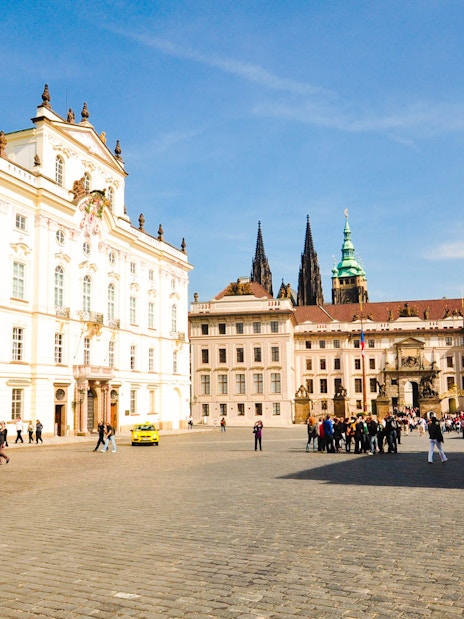 Prague Castle courtyard with tourists exploring historic architecture.