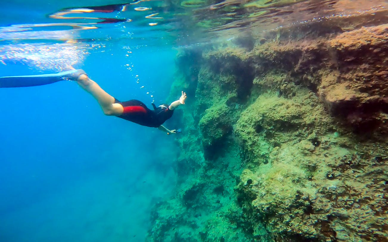 Snorkeler exploring underwater rock formations in Nea Makri, Athens.
