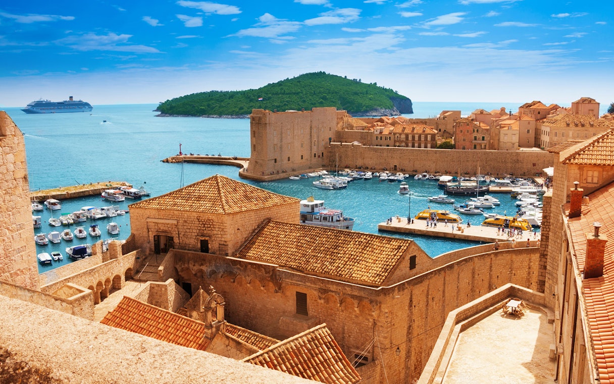 Old town harbor with boats and cruise ship in Dubrovnik, Croatia, viewed from city walls.