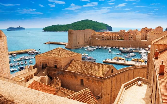 Old town harbor with boats and cruise ship in Dubrovnik, Croatia, viewed from city walls.