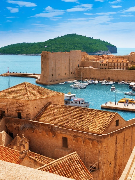Old town harbor with boats and cruise ship in Dubrovnik, Croatia, viewed from city walls.