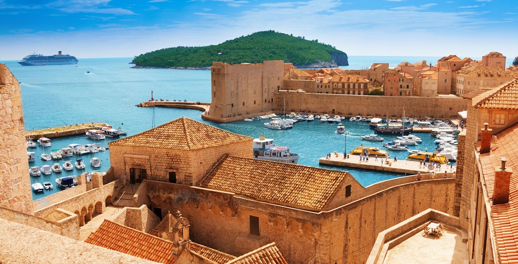 Old town harbor with boats and cruise ship in Dubrovnik, Croatia, viewed from city walls.