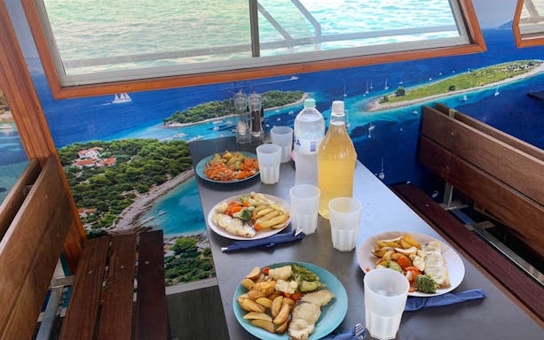 Dinner setup on Split Riviera sunset cruise with sea view.