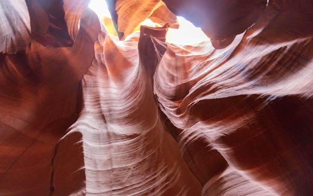 Antelope Canyon's swirling sandstone formations with sunlight filtering through.