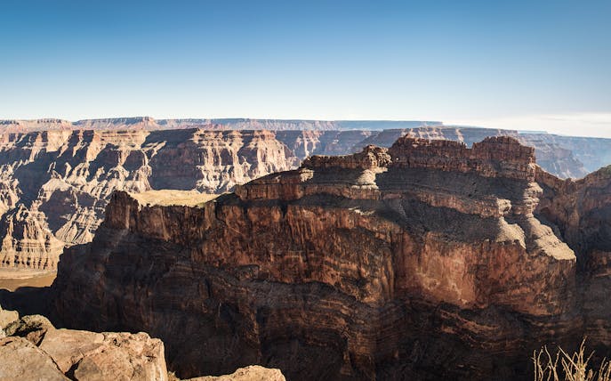 Grand Canyon West Rim cliffs under clear sky.