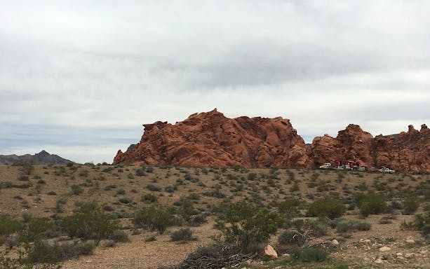 Red rock formations in Valley of Fire with vehicles in the foreground, Nevada.