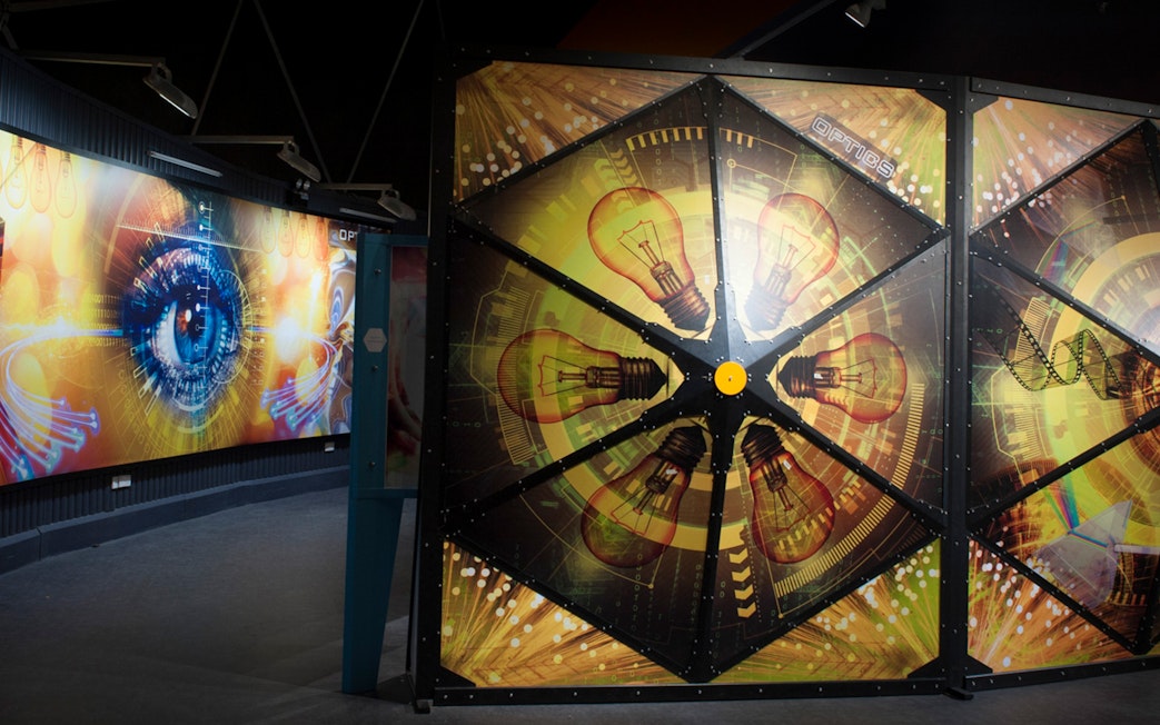 Interactive exhibit with light bulb and eye graphics at Tech Dome Penang.