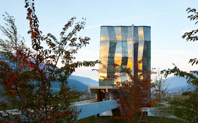 Swarovski Crystal Worlds entrance with modern glass architecture and surrounding trees.