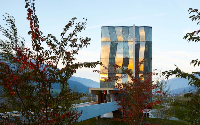 Swarovski Crystal Worlds entrance with modern glass architecture and surrounding trees.