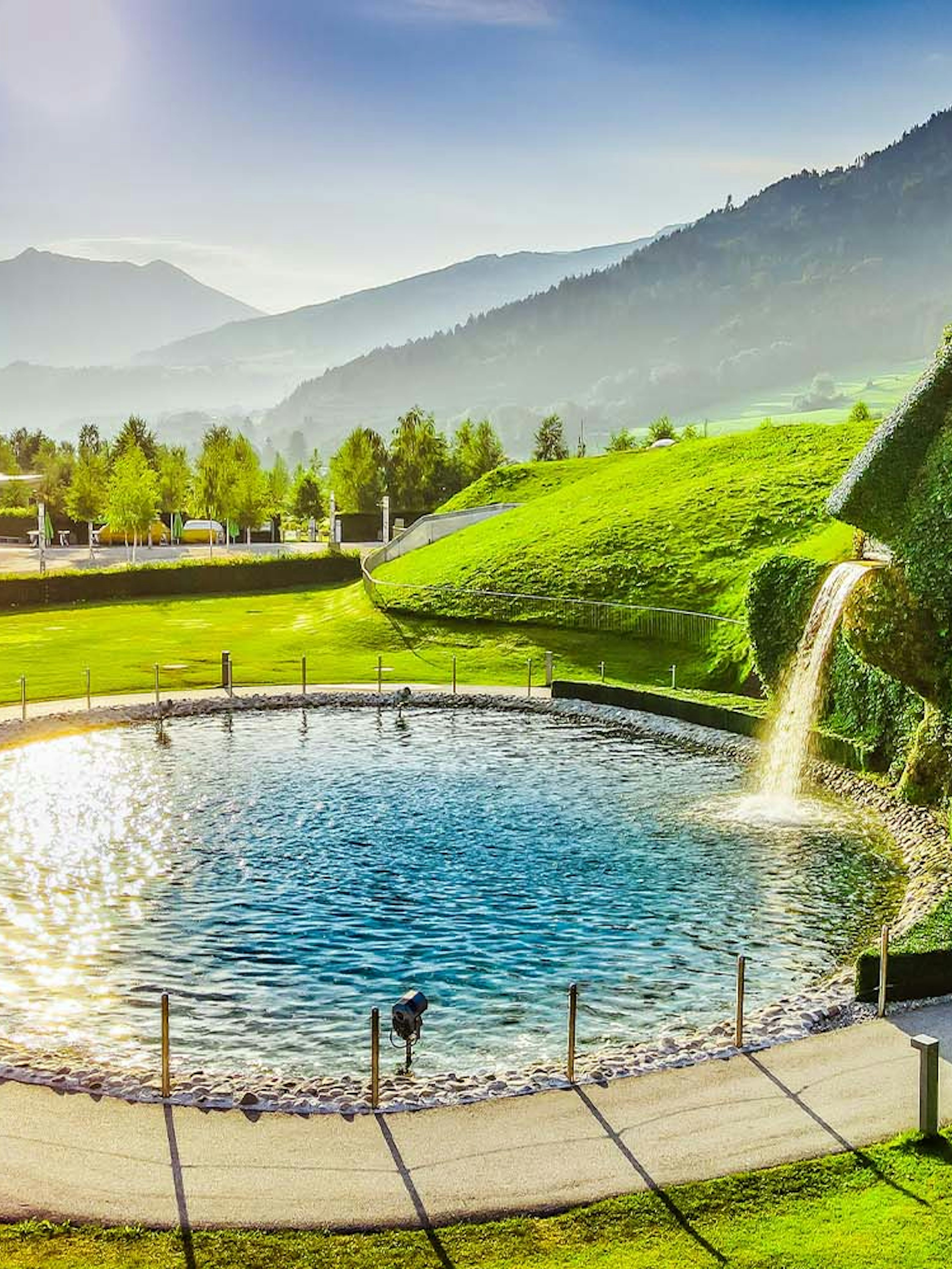 Swarovski Crystal Worlds entrance with giant grass-covered head and waterfall in Innsbruck, Austria.
