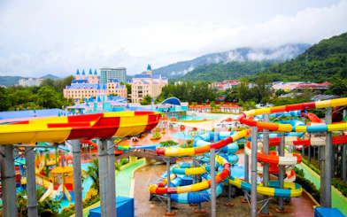 Colorful water slides at Splash Out water park, Langkawi, with scenic mountain backdrop.