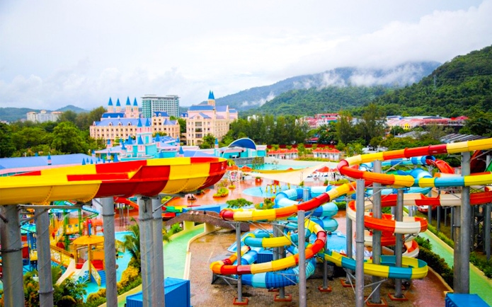 Colorful water slides at Splash Out water park, Langkawi, with scenic mountain backdrop.