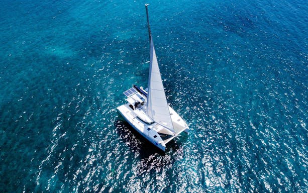 Catamaran sailing on clear blue waters during Caldera Day Cruise.