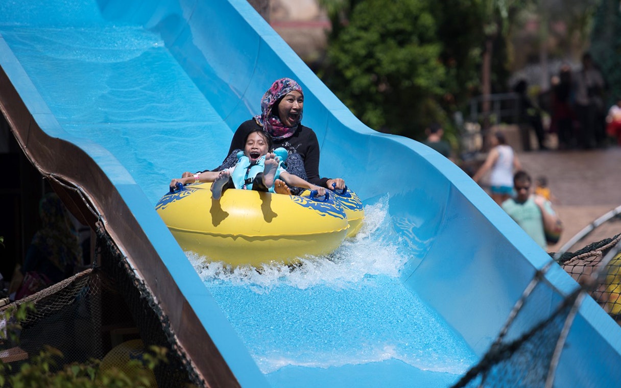 Family enjoying a water slide at Wet World Water Park Shah Alam.