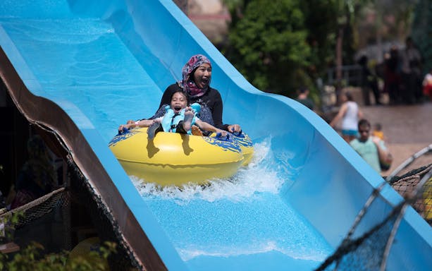Family enjoying a water slide at Wet World Water Park Shah Alam.