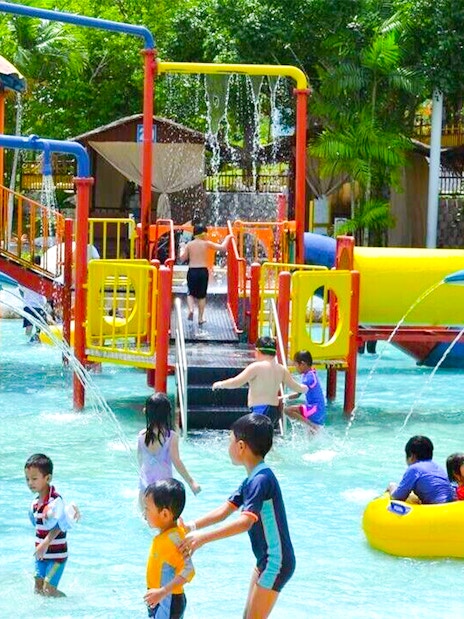 Family enjoying water slides and pool at A'Famosa Melaka Waterpark, Malaysia.