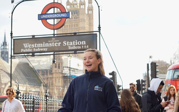 Tour guide at Westminster Station, London, with Big Ben in the background.
