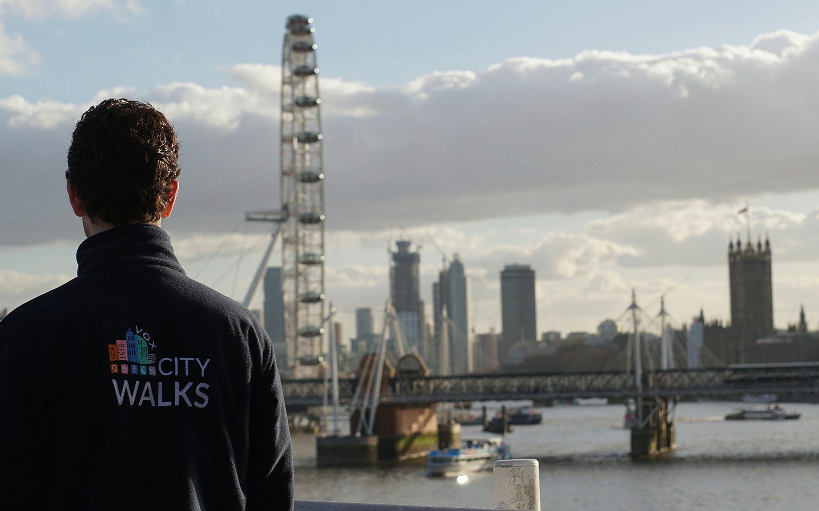 Guide overlooking the London Eye and Thames River on a city walking tour.