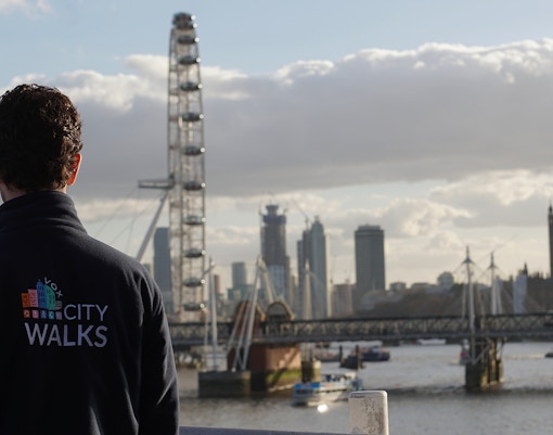 Guide overlooking the London Eye and Thames River on a city walking tour.