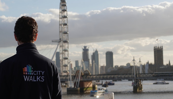 Guide overlooking the London Eye and Thames River on a city walking tour.