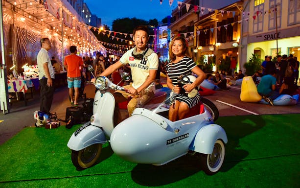 Couple on vintage Vespa sidecar during Singapore night tour.