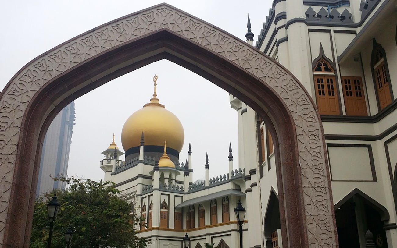 Sultan Mosque's golden dome framed by an arch in Singapore.