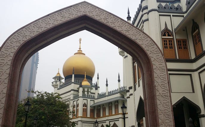 Sultan Mosque's golden dome framed by an arch in Singapore.