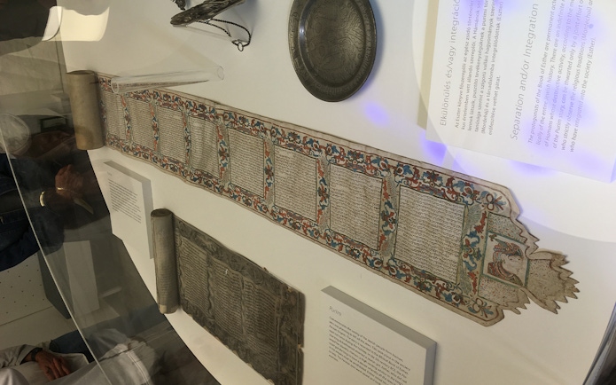 Scroll with Hebrew text and colorful border on display at Dohany Street Synagogue, Budapest.