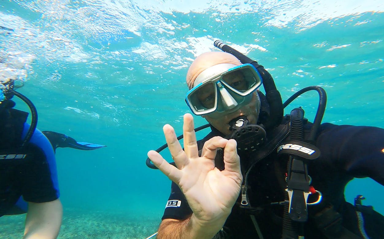 Scuba diver signaling OK underwater in Nea Makri, Athens.