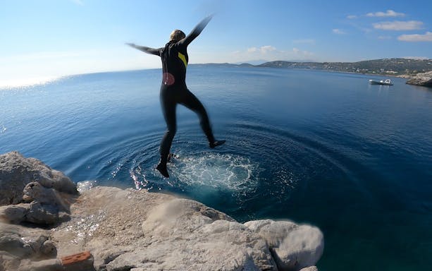 Person cliff diving into the sea during a boat trip in Nea Makri, Athens.