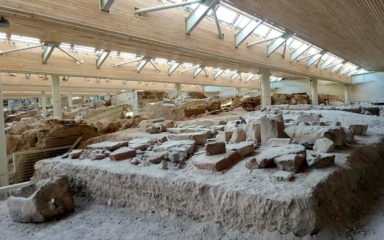 Akrotiri ruins under protective structure on guided tour in Santorini, Greece.