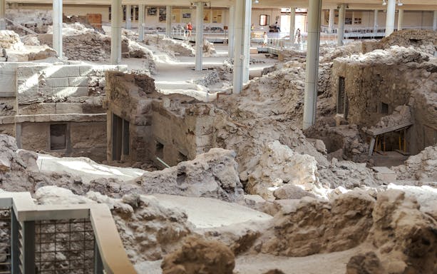 Akrotiri ruins with ancient stone structures on a guided tour in Santorini, Greece.