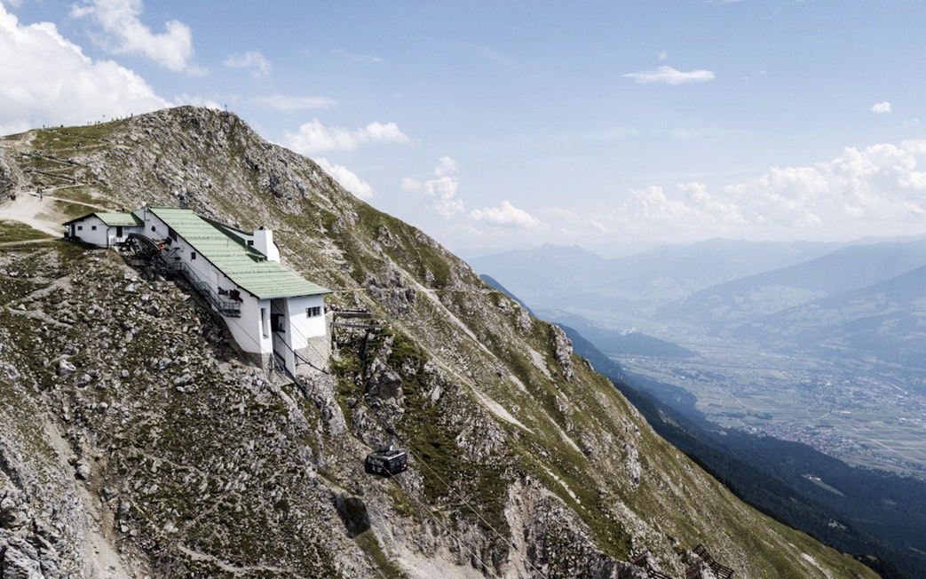 Mountain hut on Nordkette with cable car, overlooking Innsbruck valley, Austria.