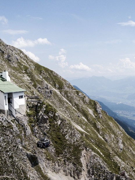 Mountain hut on Nordkette with cable car, overlooking Innsbruck valley, Austria.