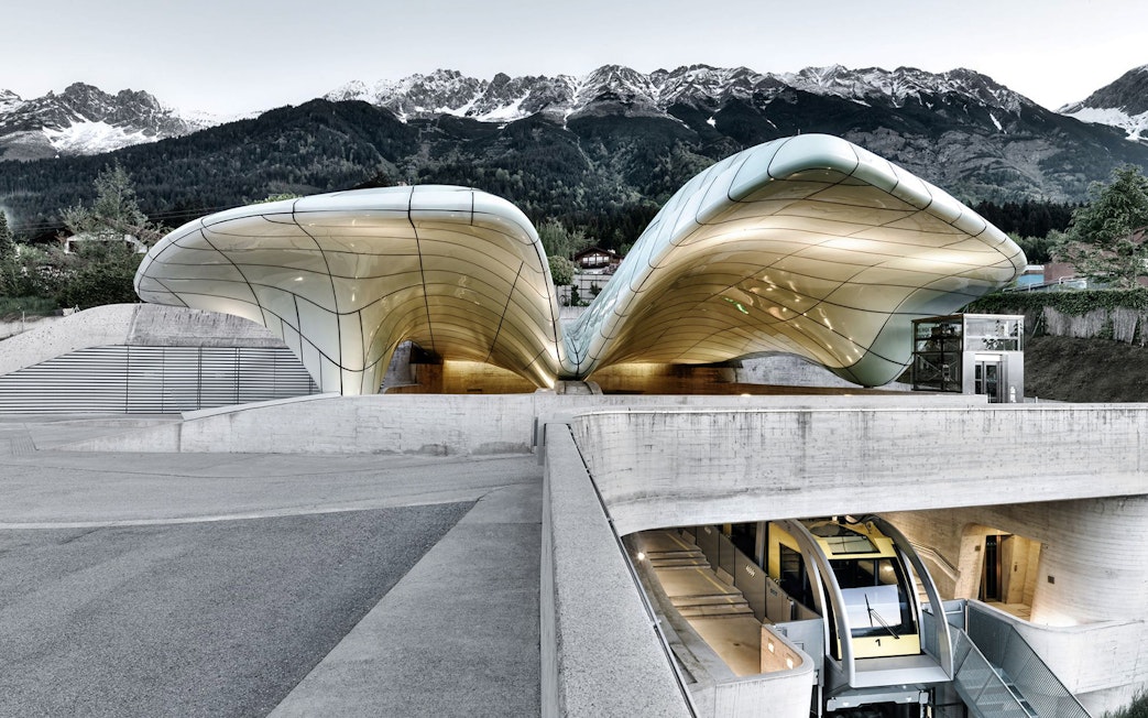 Hungerburgbahn funicular station with futuristic design in Innsbruck, Austria, against mountain backdrop.