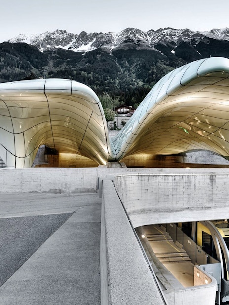 Hungerburgbahn funicular station with futuristic design in Innsbruck, Austria, against mountain backdrop.