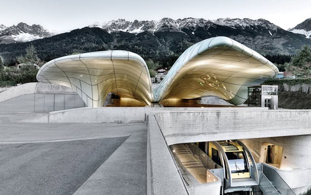 Hungerburgbahn funicular station with futuristic design in Innsbruck, Austria, against mountain backdrop.